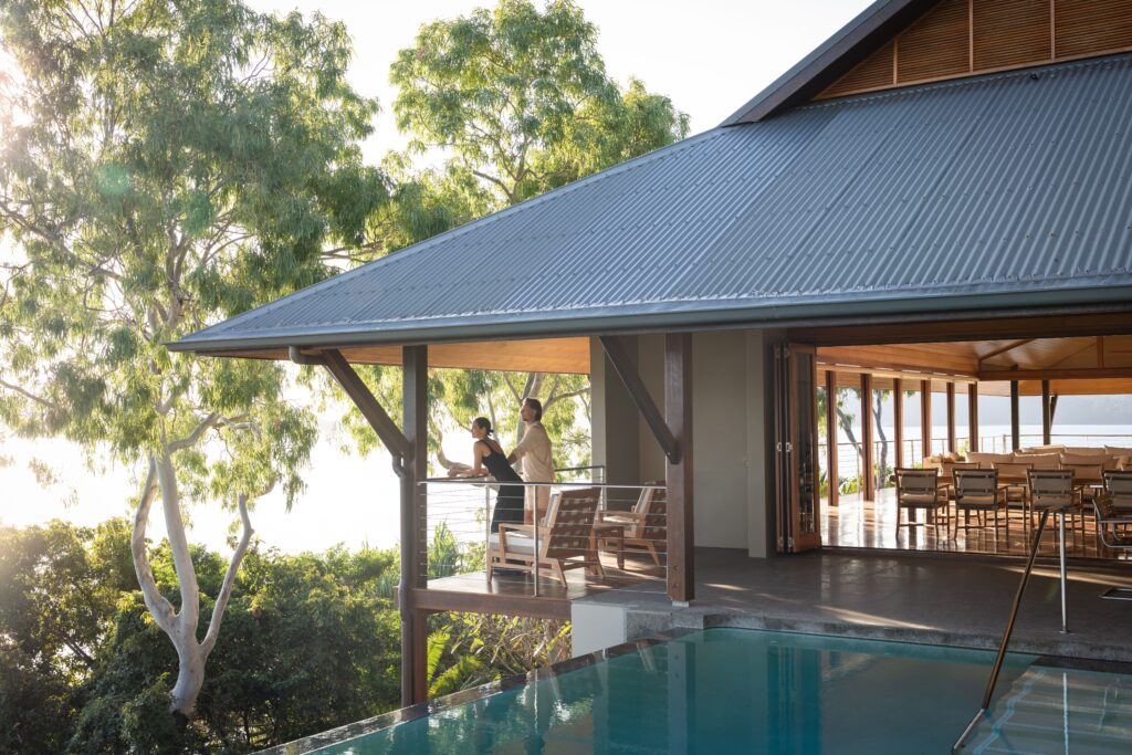 Travelers stand on the balcony of their luxury accommodation at Qualia on Hamilton Island in the Whitsundays during their Australia vacation.