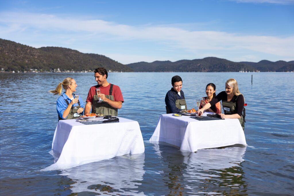 Travelers to Australia enjoying an in-water oyster dining experience