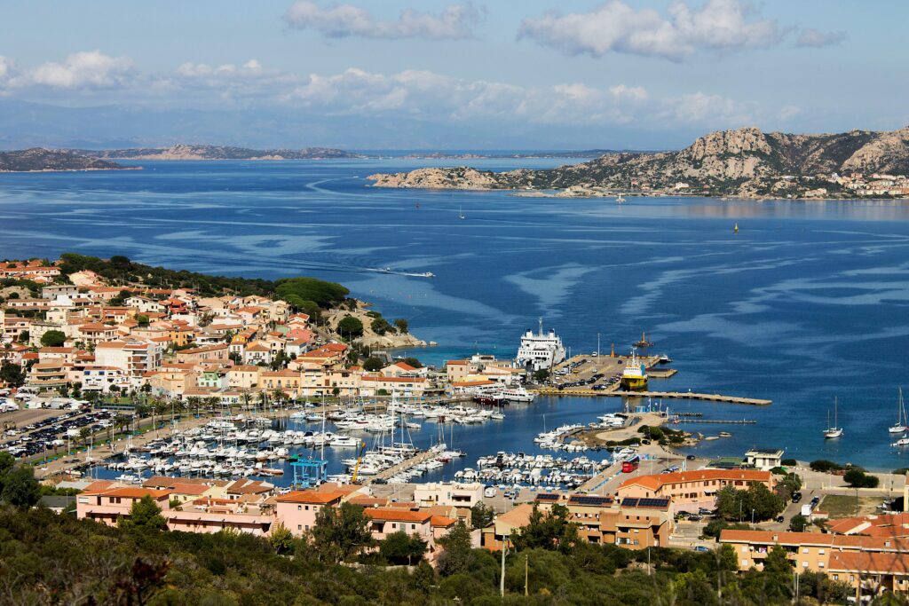 Coastal town and marina in Sardinia in summer, one of the best times to visit Italy for beach destinations